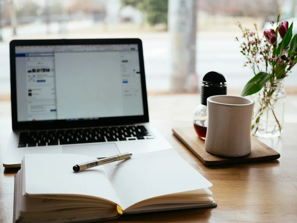Writer creating content on laptop with notebook